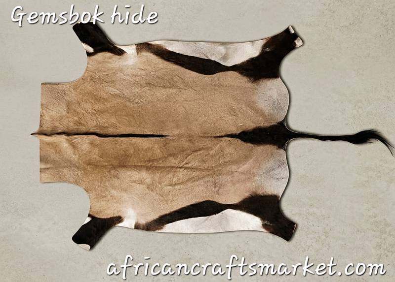 Large premium tanned African gemsbok skin hide flat lay showcasing the natural fawn-gray coat, bold black spine stripe, and striking white flank markings