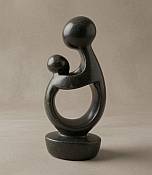 Soapstone mother and child Genuine handcrafted African stone mother and infant statue, showcasing a polished, tactile finish and natural mineral grain