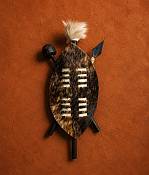AHandcrafted 25cm Zulu Warrior Shield Handcrafted 25 cm Zulu warrior hide shield featuring traditional woven leather accents and a central wood support staff